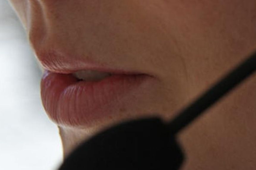 Primer plano de la boca de una mujer con un micrófono de auriculares.