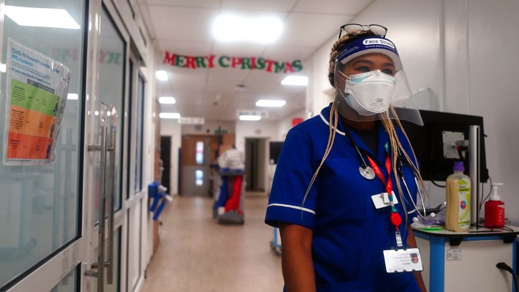 A member of staff walks through a ward for Covid patients at King's College Hospital, in south east London. Picture date: Tuesday December 21, 2021